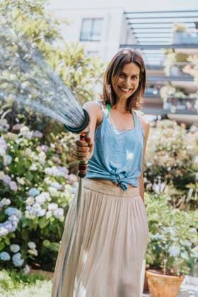 IMAGO Creative: Sommer, Sommertage im Garten Woman spraying water through garden hose model released property released, MFF08809