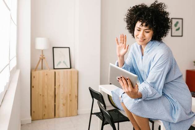 Happy woman waving hand on video call through tablet PC at home model released property released, XLGF02833