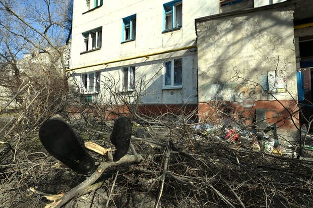 SIEVIERODONETSK, UKRAINE - MARCH 23, 2022 - Man s slippers hang on a tree branch lying on the ground near the entrance to an apartment building, Sievierodonetsk, Luhansk Region, eastern Ukraine. Sievierodonetsk during Russian invasion  Copyright: xAlbertxKoshelevx