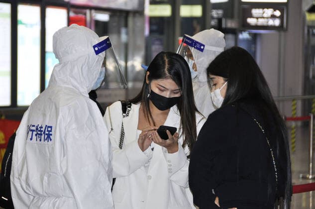 COVID-19 lockdown in Shanghai Officials in protective gear ask arriving passengers at a railway station in Shanghai to show documents certifying they are COVID-19 negative on March 28, 2022, as a citywide lockdown starts in the Chinese city the same day.  A14AA0001273987P
