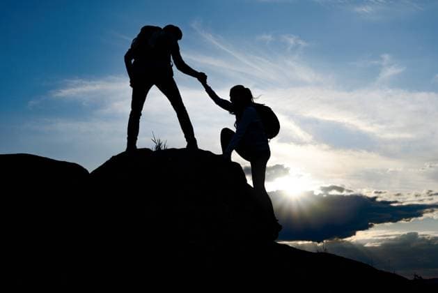 IMAGO Creative: Sommer, In den Bergen Couple of Young Happy Travelers with Backpacks Hiking in the Mountains at Warm Summer Sunset. Man Helping Woman to Climb to the Top of the Rock. Family Travel and Adventure Concept., model released, , property released, , 32503862.jpg, sun, travel, background, hand, love, woman, family, man, silhouette, sport, nature, help, mountain, climb, climber, teamwork, adventure, people, summit, companion, friend, two, rescue, sunset, sunlight, partner, hiker, rock, danger, sunrise, altitude, peak, backpackers, cliff, assistance, climbing, cloud, friendship, hiking, light, mountaineering, outdoors, risk, couple, blue, outdoor, top, up, lift