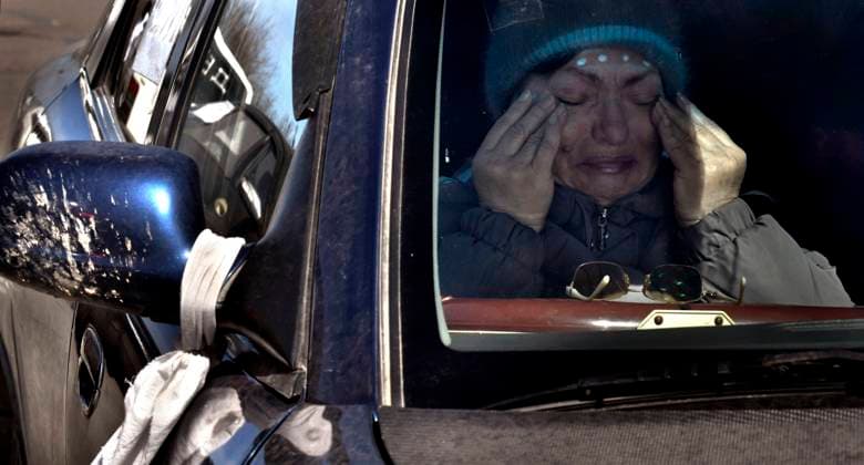 March 28, 2022, Zaporizhia, Ukraine: Tanya Lyapina weeps as displaced people fleeing desperately brutal conditions of the Russian invasion of Mariupol evacuate in battered cars with white strips of cloth and signs saying Ã¢â‚¬ËœChildrenÃ¢â‚¬â ¢ through Zaporizhia, Ukraine on March 28, 2022. The refugee exodus is the largest in Europe since WWII. Zaporizhia Ukraine - ZUMAg208 20220328_zap_g208_009 Copyright: xCarolxGuzyx
