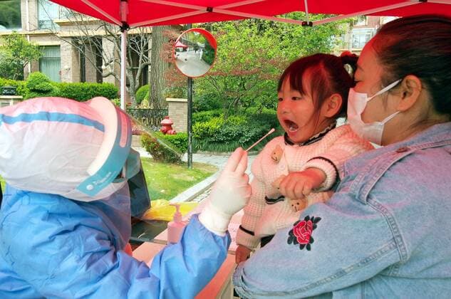 Coronavirus in China, Eindrücke aus Shanghai (220401) -- SHANGHAI, April 1, 2022 -- A medical worker takes a swab sample from a little girl for nucleic acid test in Minhang District of east China s Shanghai, April 1, 2022. The second phase of closed-off management in Shanghai has come into force in areas west of the Huangpu River on Friday amid a recent spike in COVID-19 infections, according to local authorities. As scheduled, nucleic acid testing will be held from Friday to April 5 for around 16 million people, and 12 districts will be put under temporary closed-off management. ) CHINA-SHANGHAI-COVID-19-TEST CAMPAIGN (CN) RenxLong 