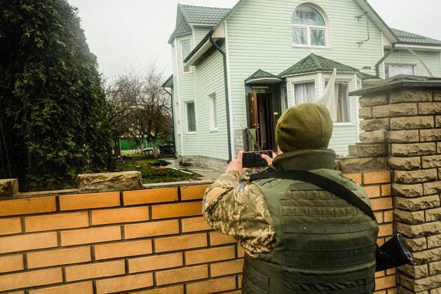 April 3, 2022, Kyiv, Ukraine: A Ukrainian soldier takes photographs of dead civilians in a yard in Bucha, a suburb of the capital city of Kyiv. As Russian troops withdraw from areas north of Ukraine s capital city of Kyiv Ukrainian officials call the heavy civilian casualties found dead in the city of Bucha a deliberate war crime, sparking International condemnation. Kyiv Ukraine - ZUMAs197 20220403_zaa_s197_207 Copyright: xMatthewxHatcherx