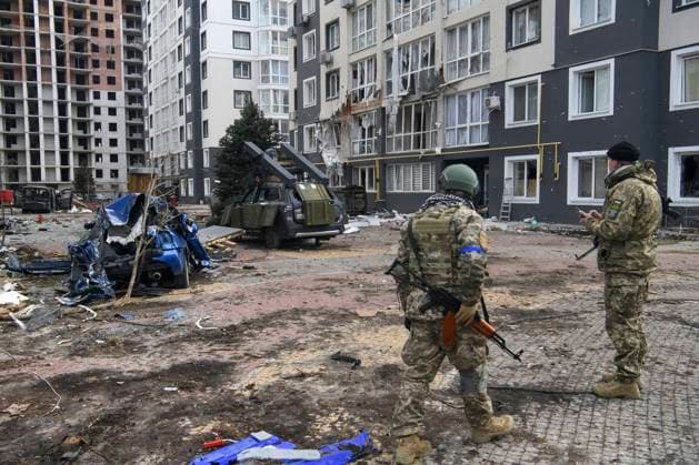 Ukraine-Krieg, Jahrestag der Invasion, Chronologie der Ereignisse, Archivbilder Ukraine-Konflikt, Eindrücke aus Butscha Situation In The Recaptured By The Ukrainian Army Bucha City Near Kyiv, Ukraine Ukrainian servicemen stands near Destroyed civil vehicles near a damaged residential building in the recaptured by the Ukrainian army Bucha city near Kyiv, Ukraine, 04 April 2022. Bucha Ukraine  Copyright: xMaxymxMarusenkox originalFilename: musienko-notitle220404_npswt.jpg