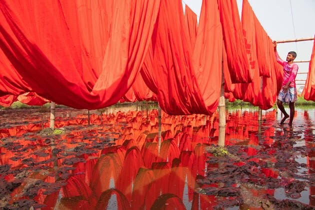 IMAGO Nature: Unsere Erde, Klimawandel, Baumwolle Bangladesch, Kleidung aus Textilfabrik wird zum trocknen in Narayanganj aufgehängt Colorful Fabrics Production Factory NARAYANGANJ, BANGLADESH - APRIL 5, 2022: Workers hanging thousands of different coloured fabrics to dry it, on flooded field during the final part of the dying process in a fabric factory. The cloths are dyed using machines and laid out in nearby fields as it is cheaper and more sustainable to dry them out in sunlight for to 6 hours, to can start manufacturing of clothes. On April 5, 2022 in Narayanganj, Bangladesh. (Photo by Joy Saha Eyepix Group) Copyright: xJoyxSahax xEyepixxGroupx EYEPIX_JS_05042022_59652