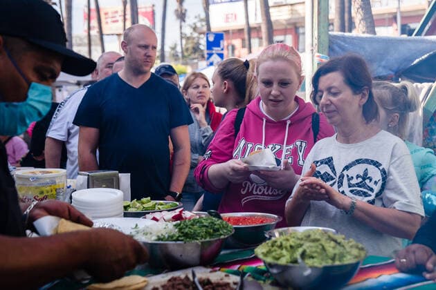 Ukrainians who fled to Mexico amid Russia s invasion of Ukraine wait in line to eat tacos prepared by Fundacion Binacional Tijuana Sin Hambre A.C., while they wait at a makeshift camp near the San Ysidro Port of Entry of the U.S.-Mexico border on Monday, April 4, 2022 in Tijuana, Mexico. The refugees are given a number so they do not have to wait in line as the United States said they will accept 100,000 Ukrainian refugees due to the Russian invasion of Ukraine.  MEX2022040423 ARIANAxDREHSLER