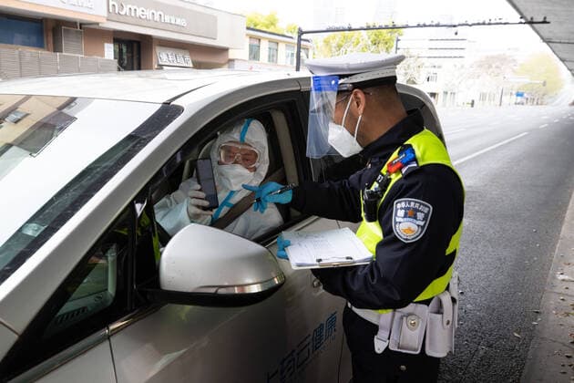 (220406) -- SHANGHAI, April 6, 2022 -- A policeman checks the special pass and personal information of the medicine deliveryman Ye Yifei in Shanghai, east China, April 5, 2022. During the temporary closed-off management period in Shanghai, supply and delivery of special drugs to those patients who need them is particularly important. A pharmacy called Shanghai Pharma E Pharmacy, which sells more than 260 new drugs, special drugs and drugs for rare diseases, stays in business to supply and deliver the medicines. ) CHINA-SHANGHAI-MEDICINE-DELIVERY (CN) JinxLiwang 