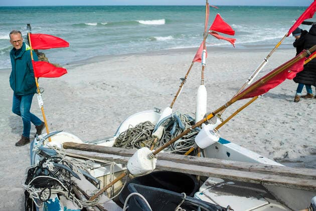 Kleine Boote von Küstenfischen liegen am Strand im Ostseebad von Ahrenshoop. Ahrenshoop