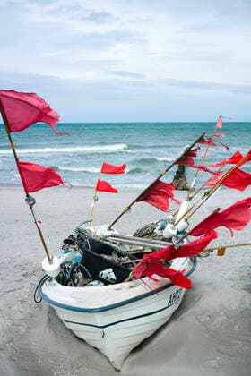 Kleine Boote von Küstenfischen liegen am Strand im Ostseebad von Ahrenshoop. Ahrenshoop