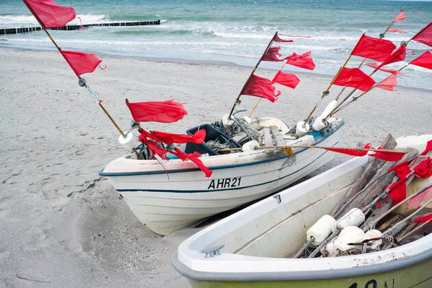 Kleine Boote von Küstenfischen liegen am Strand im Ostseebad von Ahrenshoop. Ahrenshoop