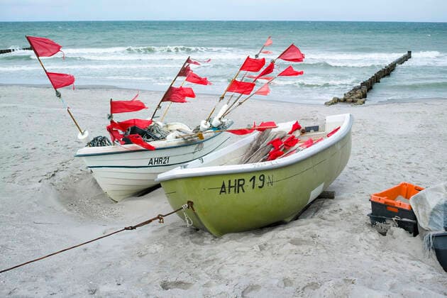 Kleine Boote von Küstenfischen liegen am Strand im Ostseebad von Ahrenshoop. Ahrenshoop