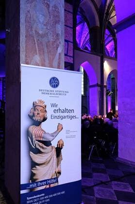 Benefizkonzert in St. Kornelius Aachen-Kornelimünster, 10.04.2022: Benefizkonzert der Reihe Grundton D mit dem Vokalensemble Singer Pur in der ehemaligen Abteikirche St. Kornelius, die im Juli 2021 vom Hochwasser stark geschädigt wurde. Veranstalter waren die Kulturinitiative Kornelimünster, der Deutschlandfunk und die Deutsche Stiftung Denkmalschutz. Das Programm bestand aus geistlicher Vokalmusik aus Deutschland und dem Baltikum. Denkmalschutz-Plakat: Wir erhalten Einzigartiges. Aachen Kornelimünster NRW Deutschland