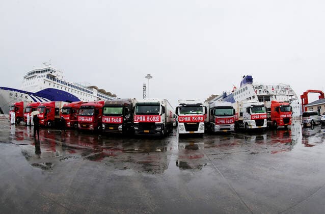 (220413) -- SHENYANG, April 13, 2022 -- Trucks loaded with food for Shanghai are seen before shipping at Dalian Port, northeast China s Liaoning Province, April 12, 2022. The commercial department of Liaoning organized about 2,300 tons of rice, flour, cooking oil, vegetables and other food for citizens in Shanghai to overcome a local COVID-19 resurgence. The first batch of 900 tons of living materials were shipped from Dalian on Tuesday. CHINA-LIAONING-SHANGHAI-FOOD-SUPPORT (CN) YangxQing 