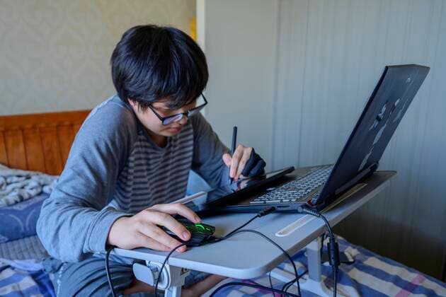 April 11, 2022, Shanghai, China: ZHENG TIANHAO is a college student who has been forced to take online classes due to the Covid-19 outbreak in his hometown of Shanghai. Zheng is a student majoring in Graphic design and is an accomplished artist. Here, he is completing a poster design for one of his courses. Shanghai China  - ZUMAemic 20220411_mda_l207_111 Copyright: xMarkxLentx