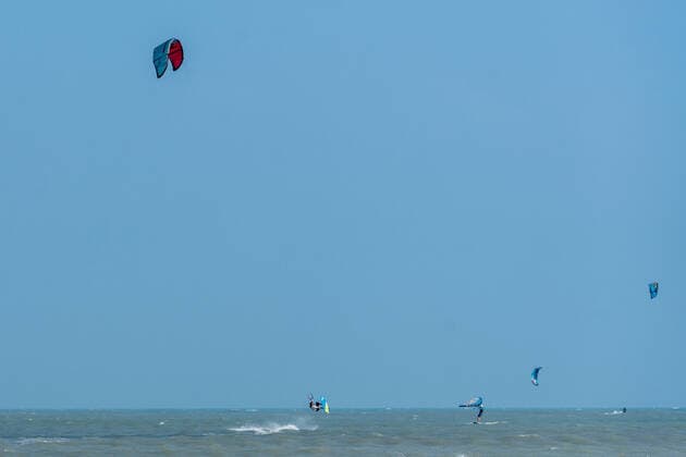 IMAGO Creative: Sommer Sport - Strand A kite surfer jumps out of the water while kiting in the Gulf of Mexico at South Padre Island, Texas. Other kite surfers and a wing surfer are nearby. South Padre Island Texas United States Copyright: xJonxG.xFullerx 7550-JGF-watersports-Kite Surfing-US-TX