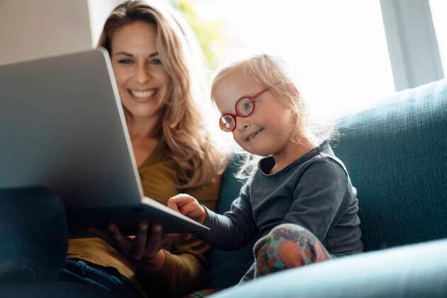 Little girl wearing eyeglasses using laptop sitting by mother on sofa in living room model released, Symbolfoto property released, JOSEF08138