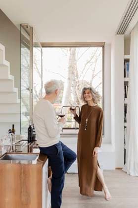 Senior couple with wineglasses standing in kitchen at hotel apartment model released, Symbolfoto property released, EIF03754