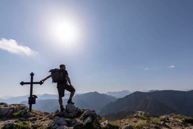Germany, Bavaria, Sun shining over silhouette of male hiker standing by Fockenstein summit cross model released, Symbolfoto, FOF13102