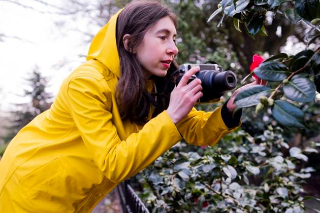 Young woman photographing flower through camera in forest model released, Symbolfoto, AMWF00237