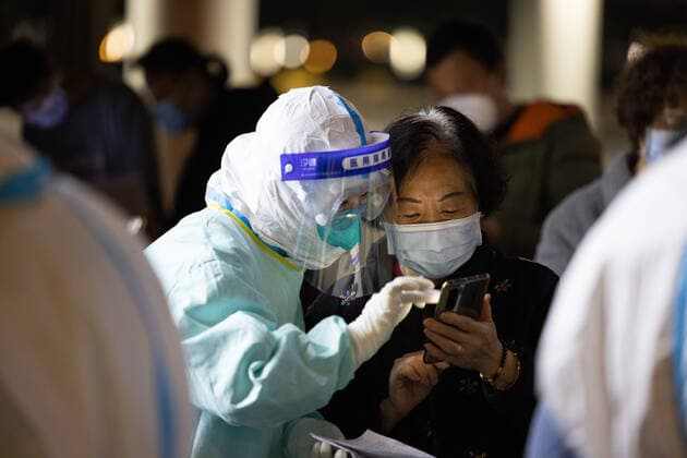 (220424) -- SHANGHAI, April 24, 2022 -- A medical worker helps Huang Dongfang regisiter on a smart phone at a makeshift hospital in Shanghai, east China, April 23, 2022. Huang Dongfang, who lives in a three-and-a-half-story old apartment in Guangfu residential area, recovered from COVID-19 infection and returned her home on Saturday evening. ) CHINA-SHANGHAI-COVID-19-PATIENT-RECOVERY (CN) JinxLiwang 