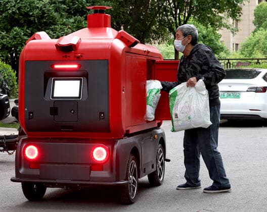 (220425) -- SHANGHAI, April 25, 2022 -- A resident collects goods from an unmanned delivery vehicle in a community of Jiading District, east China s Shanghai, April 25, 2022. Many communities in Shanghai have been using unmanned delivery vehicles to distribute supplies to residents amid challenges caused by the recent resurgence of COVID-19. ) CHINA-SHANGHAI-COVID-19-SUPPLIES-DELIVERY (CN) ChenxJianli 