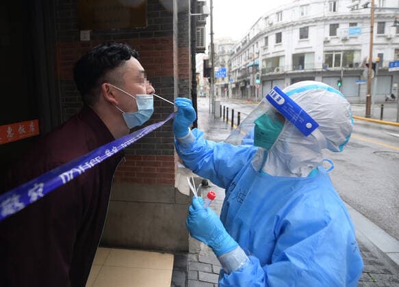 (220426) -- SHANGHAI, April 26, 2022 -- A staff member takes a swab sample from a citizen discharged from a makeshift hospital for nucleic acid test in Huangpu District, east China s Shanghai, April 26, 2022. A mass nucleic acid test was carried out in Shanghai on Tuesday in closed-off management areas, restrictive control areas, and prevention areas. Shanghai has divided the whole city into areas belonging to three categories as part of targeted efforts to overcome a local COVID-19 resurgence. ) CHINA-SHANGHAI-COVID-19-NUCLEIC ACID TESTING (CN) LixHe 