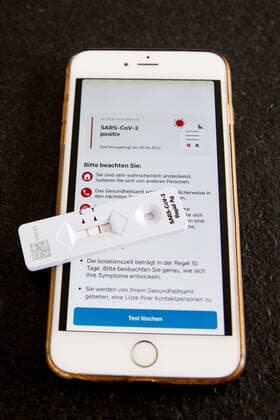 Bamberg, Deutschland 28. April 2022: Themenbilder - Symbolbilder - Coronavirus - 2022 Auf einem Tisch liegt ein Antigen-Schnelltest auf das Coronavirus SARS-CoV-2 dieser das Ergebnis Positiv anzeigt, daneben liegt ein Handy mit der Mitteilung das das Ergebnis des PCR Test Befundes auch Positiv ist. Bayern Copyright: xFotostandx xK.xSchmittx