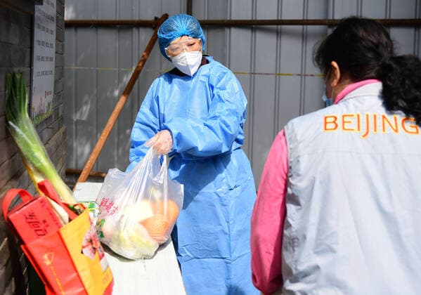 (220428) -- BEIJING, April 28, 2022 -- A resident picks a parcel with the help of a community worker in a community in Dongcheng District of Beijing, capital of China, April 28, 2022. During the latest resurgence of COVID-19 infections in Beijing, people from different walks of life have joined the fight against the coronavirus, working against the clock to offer hearty support. ) CHINA-BEIJING-COVID-19 (CN) ZhangxChenlin 