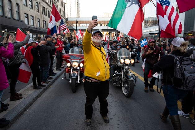 April 29, 2022, Ottawa, ON, CAN: A participant takes a selfie in front of motorcycles as they get ready to ride along Rideau Street during a demonstration, part of a convoy-style protest participants are calling Rolling ThunderöÄÃ¹, in Ottawa, on Friday, April 29, 2022. Ottawa CAN  - ZUMAc35_ 20220429_zaf_c35_102 Copyright: xJustinxTangx