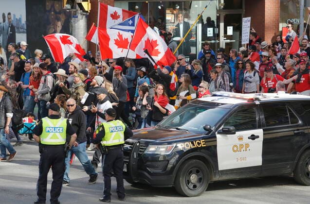 April 30, 2022, Ottawa, ON, Canada: People march past police at a demonstration, part of a convoy-style protest participants are calling Rolling Thunder , in Ottawa, on Saturday, April 30, 2022. Ottawa Canada  - ZUMAc35_ 20220430_zaf_c35_167 Copyright: xPatrickxDoylex