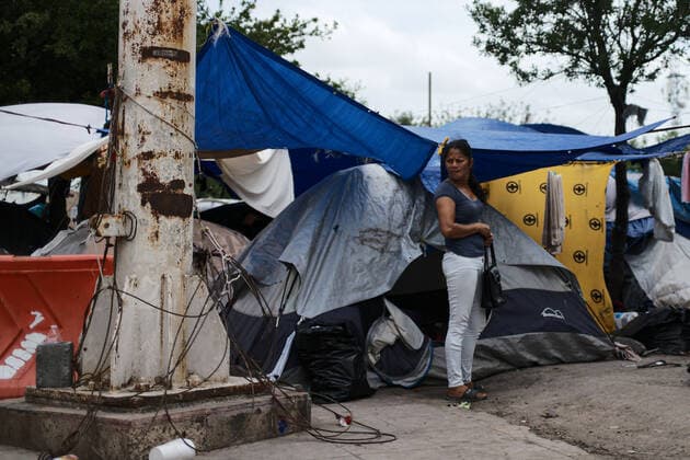 (220503) -- REYNOSA, May 3, 2022 -- A migrant stands in front of a tent at a migrant camp in Reynosa, Tamaulipas, Mexico, May 2, 2022. ) MEXICO-REYNOSA-U.S.-BORDER-MIGRANTS XinxYuewei 