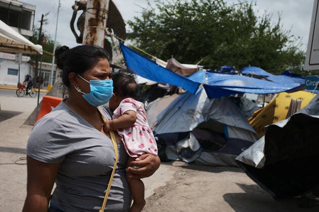 (220503) -- REYNOSA, May 3, 2022 -- A migrant with a kid walks towards a migrant camp in Reynosa, Tamaulipas, Mexico, May 2, 2022. ) MEXICO-REYNOSA-U.S.-BORDER-MIGRANTS XinxYuewei 