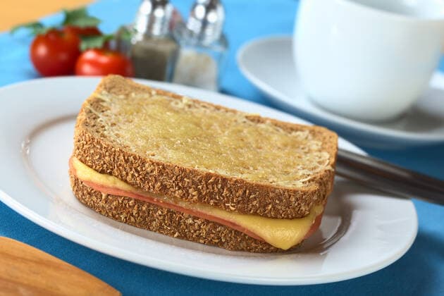 Croque Monsieur. Baked wholewheat bread sandwich filled with ham and cheese and grated cheese on top (Selective Focus, Focus on the front edge of the sandwich) , 2376215.jpg, croque monsieur , bread, sandwich, toast, wholewheat, wholewheat bread , baked, warm, cheese, ham, melted, grated, toasted sandwich , toasted, snack, food, breakfast, french cuisine , slice, piece, brown bread , whole-grain bread , wholemeal bread , brown, wholemeal, whole-grain , selective focus , nobody, horizontal, color photo , photograph, studio shot ,