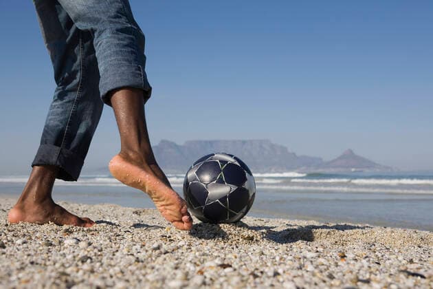IMAGO Creative: Sommer Sport - Strand Young Man Playing Soccer On Beach, model released, , 10115932.jpg, Active, Activity, Adult, African, American, Ball, Barefoot, Beach, Black, Blue, Closeup, Coastline, Copyspace, Denim, Exercise, Feet, Fitness, Foot, Football, Health, Horizontal, Jeans, Legs, Leisure, Lowsection, Man, Mountain, Nature, Ocean, One, Outdoors, Person, Playing, Practising, Recreation, Rolled Up, Sand, Sea, Shore, Side View, Sky, Soccer, South Africa, Sport, Summer, Sunny, Training, Vitality, Young, 30s,