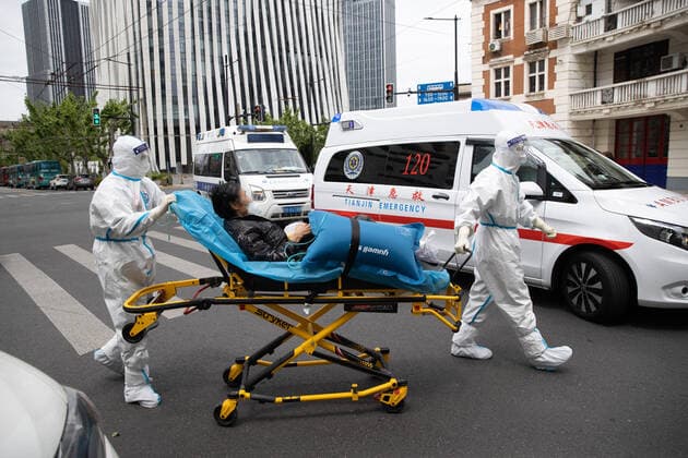 (220510) -- SHANGHAI, May 10, 2022 -- Meng Xiangjun (L) and Zhang Zhimin transfer a COVID-19 patient in east China s Shanghai, May 9, 2022. A medical emergency team consisting of 108 members with 50 ambulances from north China s Tianjin has arrived at Shanghai to assist in the city s public medical emergency service amid the COVID-19 resurgence. ) CHINA-SHANGHAI-MEDICAL TEAM-COVID-19-AID (CN) JinxLiwang 