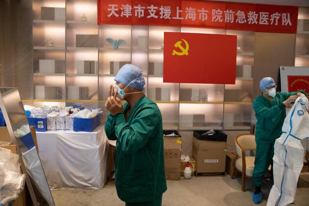 (220510) -- SHANGHAI, May 10, 2022 -- Meng Xiangjun and Zhang Zhimin (L) wear protective suits at the headquarters of a medical emergency team on Caoyang Road in east China s Shanghai, May 9, 2022. A medical emergency team consisting of 108 members with 50 ambulances from north China s Tianjin has arrived at Shanghai to assist in the city s public medical emergency service amid the COVID-19 resurgence. ) CHINA-SHANGHAI-MEDICAL TEAM-COVID-19-AID (CN) JinxLiwang 
