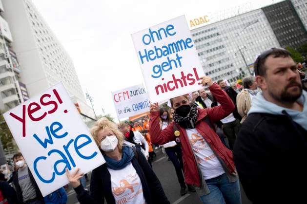 1. Mai Demo DEU, Deutschland, Germany, Berlin, 01.05.2022 Demonstrant mit Plakat Ohne Hebamme geht nichts Yes we Care gegen den Stress im Gesundheitswesen und bei der Pflege auf der Demonstration von internationalen Gewerkschaften, linken Initiativen und des Gewerkschaftsverband DGB zum 01. Mai 2022 und dem Tag der Arbeit fuer einen Fairen Lohn, Solidaritaet und gerechte Arbeitsbedingungen unter dem Motto 1.Mai Gemeinsam Zukunft Gestalten in Berlin. en: Demonstrator with a poster Nothing works without a midwife Yes we Care against the stress in healthcare and care at the demonstration of international trade unions, left-wing initiatives and the trade union association DGB on May 1st, 2022 and Labor Day for one Fair wages, solidarity and fai