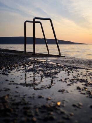 IMAGO Creative: 2022 Favoriten IMAGO Creative: Sommer Sport - Strand Ladder into the sea at the beach in Cres (Croatia), sunset in springtime, reflections in puddle Cres Croatia