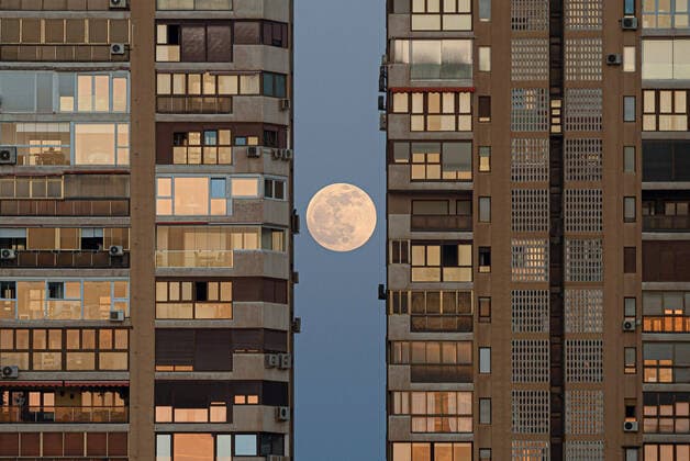 Bilder des Jahres 2022, News 05 Mai News Bilder des Tages May 15, 2022, Malaga, Spain: The full moon, known as the blood red moon is seen rising behind the buildings before a total lunar eclipse. On the night of 16 May, a total lunar eclipse will appear in the night skies and will be visible in Europe. During the total lunar eclipse, the light of the moon reflects a red and orange light. Malaga Spain - ZUMAs197 20220515_zaa_s197_301 Copyright: xJesusxMeridax