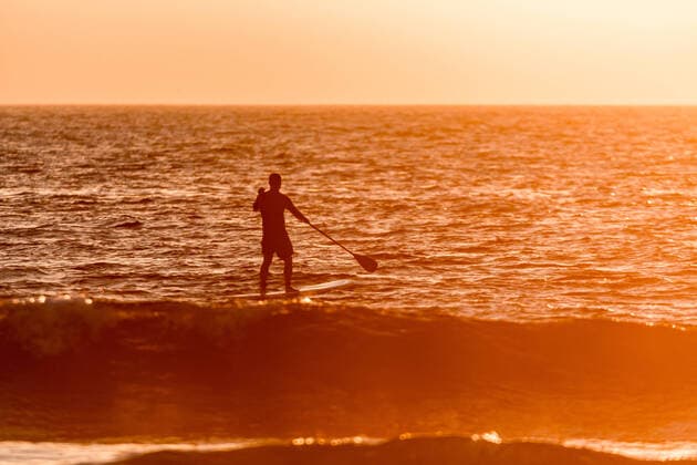 IMAGO Creative: Sommer Sport - Strand Stand up paddler silhouette at sunset. Concept about sport, surf, vacations and people., model released, , 22483792.jpg, Sport, athlete, beach, board, boarding, challenge, cool, europe, fun, green, lifestyle, male, man, nature, ocean, orange, outdoor, paddle, people, person, portugal, row, sea, sports, spray, stand, summer, sunset, surf, surfer, surfing, travel, tropical, up, water, wave, young,