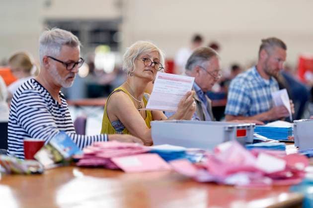 Bei der Auszählung der Briefwahlstimmen im Briefwahlzentrum in der Koelnmesse werden die roten Wahlbriefe von ehrenamtlichen Wahlhelfern auf ihre Gültigkeit überprüft, in blaue Stimmzettelumschläge eingelegt und diese in versiegelten Urnen gesammelt. (Themenbild, Symbolbild) Köln, 15.05.2022 NRW Deutschland *** When the absentee ballots are counted in the absentee ballot center at Koelnmesse, the red ballot letters are checked for validity by volunteer election workers, placed in blue ballot envelopes, and these are collected in sealed urns Topic image, symbol image Cologne, 15 05 2022 NRW Germany Copyright: xChristophxHardtx