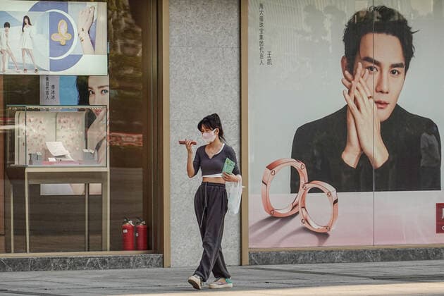 May 17, 2022, Changzhou, China: A woman wearing a face mask as a preventive measure against the spread of coronavirus walks on the road while holding a mobile phone. According to China s economy is supposed to see improvement this month despite weak business data in April, and economic activities may rebound with a gradual recovery in household spending and strong fixed-investment support in the following months, officials and experts said on Monday. They said China s economy should gradually stabilize and recover, with improvement in some key economic indicators, better containment of COVID-19 outbreaks and stronger policy support. Changzhou China - ZUMAs197 20220517_zaa_s197_382 Copyright: xSheldonxCooperx