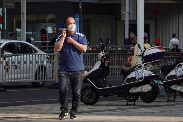 May 17, 2022, Changzhou, China: A man wearing a face mask as a preventive measure against the spread of coronavirus walks on the road while speaking on phone. According to China s economy is supposed to see improvement this month despite weak business data in April, and economic activities may rebound with a gradual recovery in household spending and strong fixed-investment support in the following months, officials and experts said on Monday. They said China s economy should gradually stabilize and recover, with improvement in some key economic indicators, better containment of COVID-19 outbreaks and stronger policy support. Changzhou China - ZUMAs197 20220517_zaa_s197_383 Copyright: xSheldonxCooperx