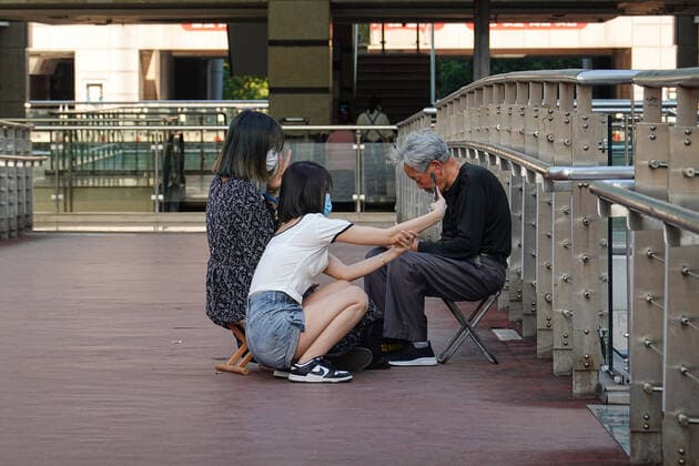 May 17, 2022, Changzhou, China: Two girls wearing face masks as a preventive measure against the spread of coronavirus take selfies in front of an old man s stall on the overpass. According to China s economy is supposed to see improvement this month despite weak business data in April, and economic activities may rebound with a gradual recovery in household spending and strong fixed-investment support in the following months, officials and experts said on Monday. They said China s economy should gradually stabilize and recover, with improvement in some key economic indicators, better containment of COVID-19 outbreaks and stronger policy support. Changzhou China - ZUMAs197 20220517_zaa_s197_376 Copyright: xSheldonxCooperx