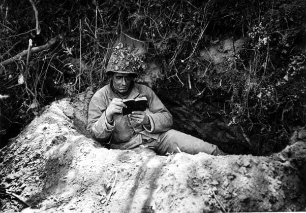U.S soldier reads a prayer book near front in St Lo sector (France), July 1944 An American soldier reads his prayer book in a foxhole near the front lines in the St Lo sector in France, (July 1944) Copyright: xPhoto12 Coll-DITE USISx DIT01068_166