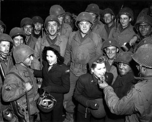 American girls with GI s in 9th U.S Army area (France), December10,1944 A member of the U.S.O. troupe (left) gives a G.I a few words of encouragement while the other girl samples a doughnut for another GI. (9th U.S Army area-France), December 10,1944 Copyright: xPhoto12 Coll-DITE USISx DIT01068_203