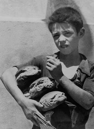 A young Sicilian receives his bread ration in Mazaro del Vallo, August 3, 1943 In Mazaro del Vallo (Sicily), a young boy had just received his bread ration, August 3, 1943 Copyright: xPhoto12 Coll-DITE USISx DIT01103_049