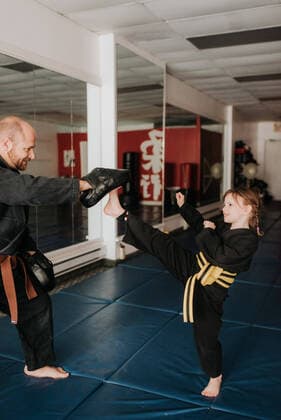 IMAGO Creative: Lokalhelden - Jugendsportbildung Coach and student practising kickboxing in studio, 05.03.2019, Copyright: xSaraxMonikax, model released, , property released, coach,studio,35 to 39 years,7 to 9 years,active lifestyle,athleticism,bonding,both male and female,caucasian ethnicity,child,childhood,communication,connections,daughter,diminishing perspective,family,family with one child,father,female,fitness,focus on foreground,friendship,full length,girl,guidance,harmony,healthy lifestyle,indoors,kickboxing,learning,looking down,looking up,male,man,March 2019 Release,martial art,martial art uniform,mid adult man,parent,portrait,practising,pre-adolescent girl,quality time,real people,self-defence,sport,sports coach,standing,strength,student,teaching,three quarter length,together IS09BY549
