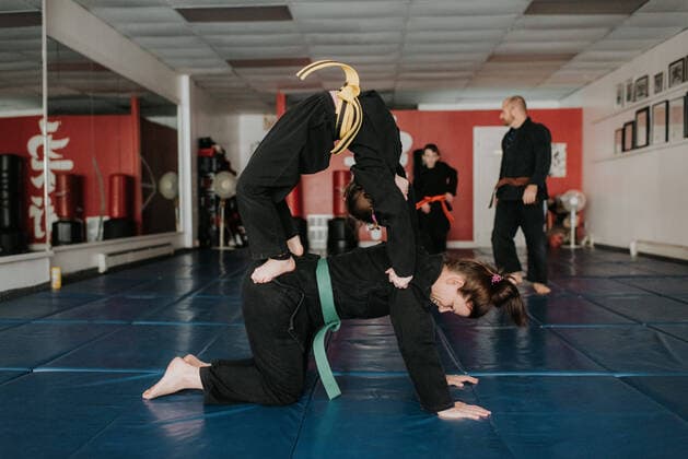 IMAGO Creative: Lokalhelden - Jugendsportbildung Coach and students practising martial arts in studio, 05.03.2019, Copyright: xSaraxMonikax, model released, , property released, coach,studio,35 to 39 years,7 to 9 years,active lifestyle,athleticism,bonding,both male and female,boy,brother,caucasian ethnicity,child,childhood,daughter,diminishing perspective,family,family with two children,father,female,fitness,focus on foreground,four people,full length,girl,guidance,harmony,healthy lifestyle,husband,indoors,learning,looking down,male,man,March 2019 Release,martial art,martial art uniform,mid adult man,mid adult woman,mother,parent,portrait,practising,pre-adolescent boy,pre-adolescent girl,quality time,real people,self-defence,sibling,sister,son,sport,sports coach,standing,strength,studen IS09BY54I